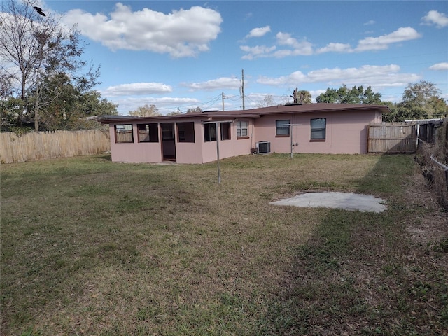 back of house featuring cooling unit and a yard