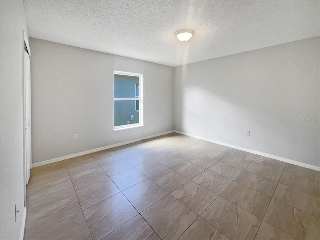 unfurnished room with a textured ceiling