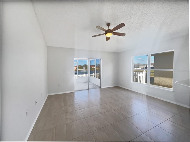 spare room featuring tile patterned flooring, ceiling fan, and a textured ceiling