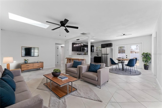 living room featuring a skylight, french doors, and ceiling fan