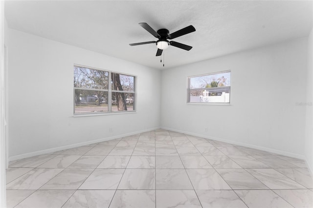 empty room with a wealth of natural light and ceiling fan