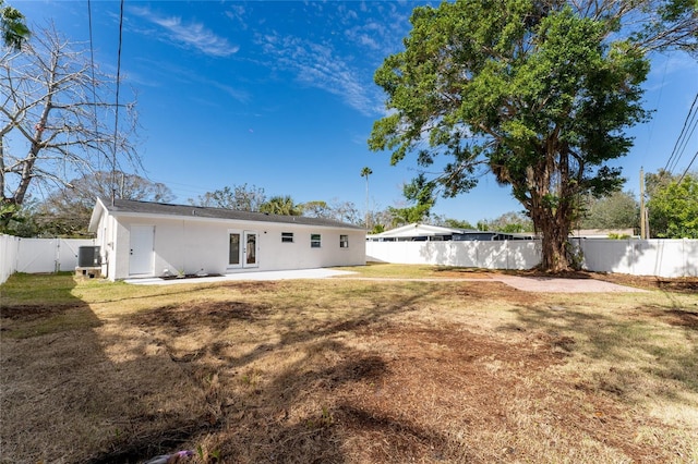 rear view of house with a yard, cooling unit, and french doors