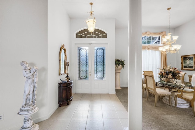 tiled foyer entrance featuring an inviting chandelier and french doors