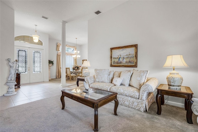 living room with french doors, light colored carpet, an inviting chandelier, and decorative columns