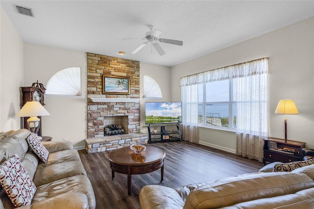 living room featuring dark hardwood / wood-style floors, a healthy amount of sunlight, a fireplace, and a textured ceiling