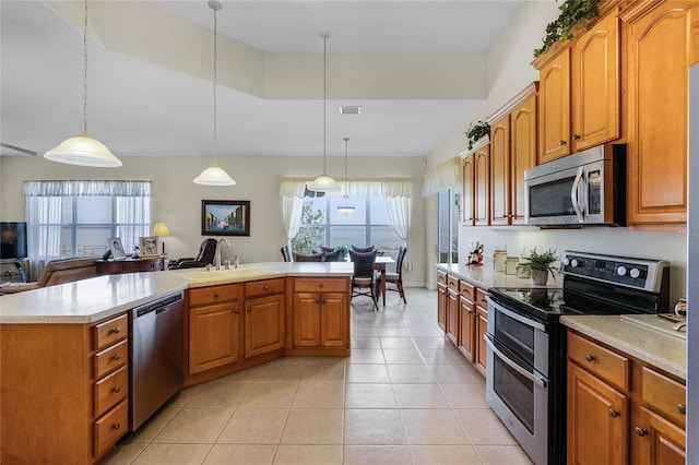 kitchen featuring sink, decorative light fixtures, a center island, light tile patterned floors, and stainless steel appliances