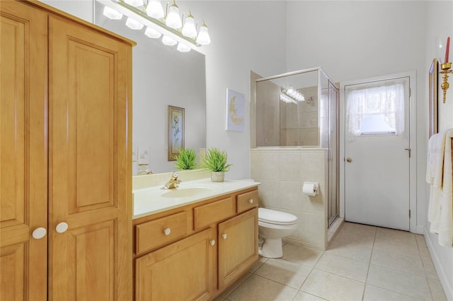 bathroom with tile patterned flooring, vanity, a shower with door, and toilet