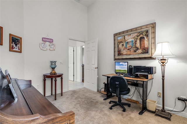 carpeted office space featuring a towering ceiling