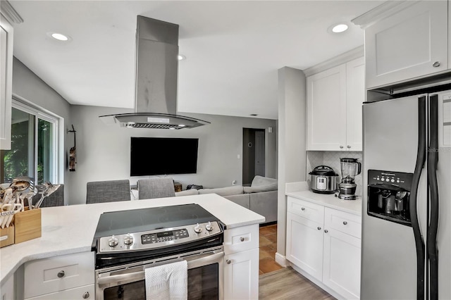 kitchen featuring light hardwood / wood-style flooring, appliances with stainless steel finishes, white cabinets, island exhaust hood, and backsplash