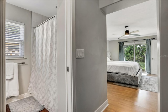 bathroom with hardwood / wood-style floors, ceiling fan, and a shower with curtain