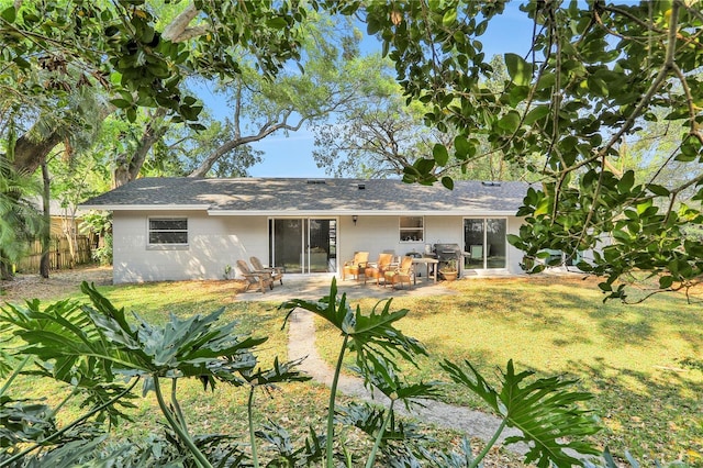 back of house with a patio and a lawn