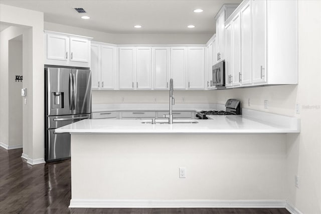 kitchen with white cabinetry, appliances with stainless steel finishes, sink, and kitchen peninsula