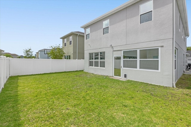 rear view of property with a lawn