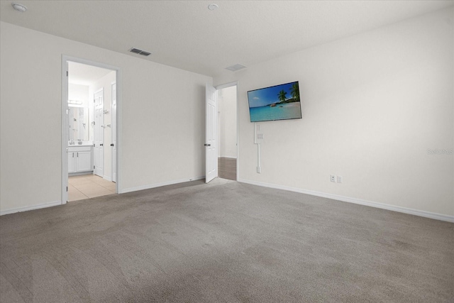 interior space with light colored carpet, visible vents, and baseboards