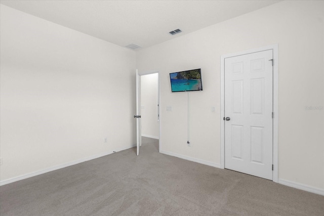 unfurnished bedroom with carpet, visible vents, and baseboards