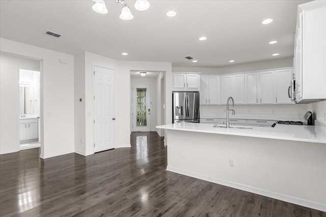 kitchen featuring stainless steel appliances, dark wood-type flooring, a sink, white cabinetry, and light countertops