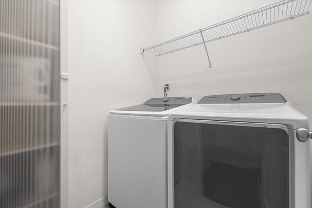 clothes washing area featuring laundry area and washer and clothes dryer