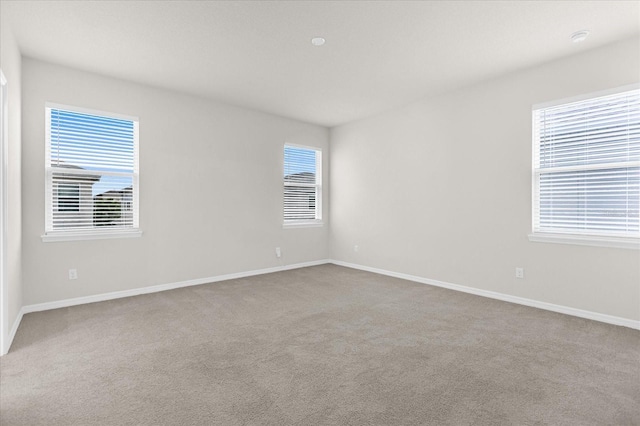 empty room featuring carpet floors and baseboards