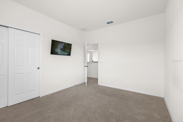 unfurnished bedroom with baseboards, visible vents, and light colored carpet