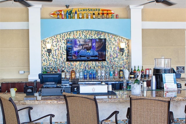 bar featuring backsplash and ceiling fan