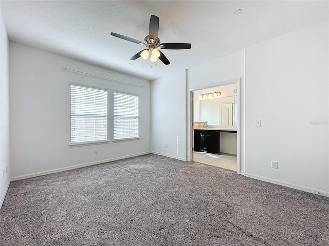 unfurnished bedroom with ceiling fan, light colored carpet, connected bathroom, and a textured ceiling