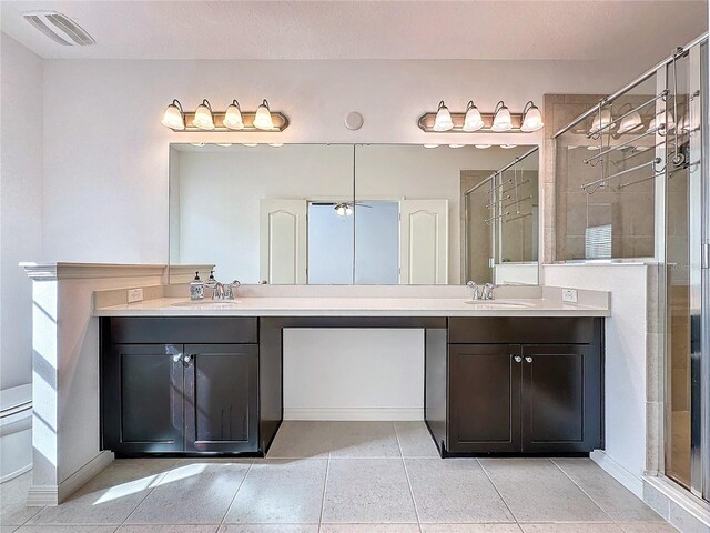 bathroom with vanity, tile patterned flooring, a shower with door, and toilet