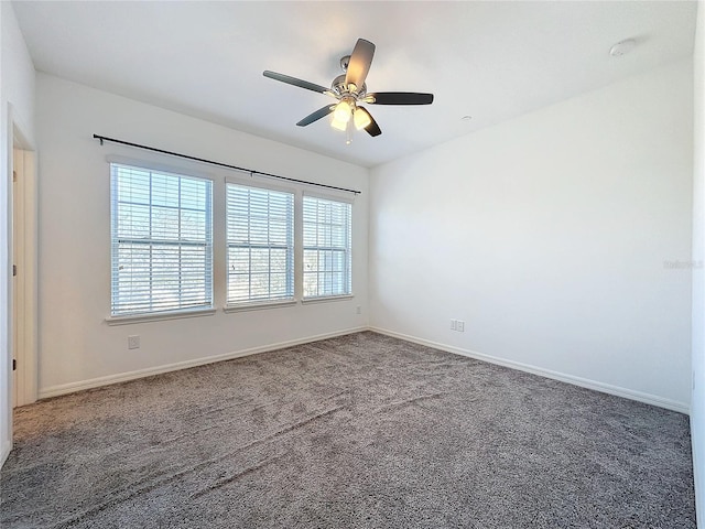 unfurnished room with ceiling fan and dark colored carpet