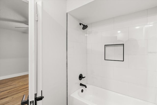 bathroom with hardwood / wood-style flooring and tiled shower / bath combo