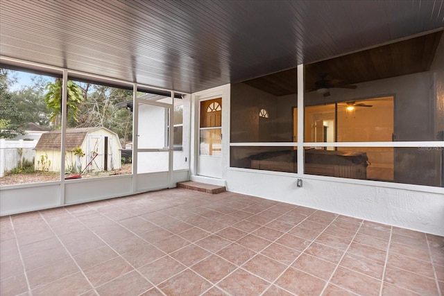 unfurnished sunroom featuring ceiling fan and wooden ceiling