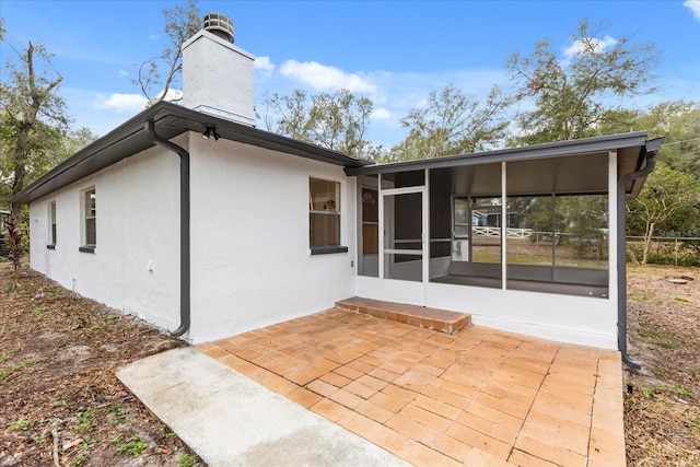 rear view of house featuring a patio area and a sunroom