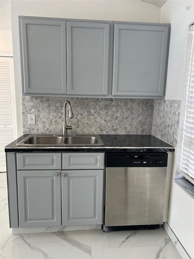 kitchen with sink, decorative backsplash, gray cabinets, and stainless steel dishwasher