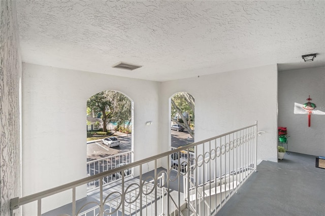 hallway with concrete floors and a textured ceiling