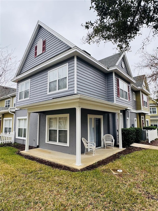 back of house featuring a patio and a lawn