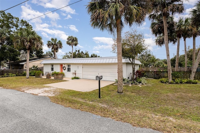 ranch-style house featuring a garage and a front lawn