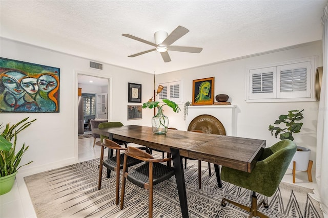 dining space with light tile patterned floors, a textured ceiling, and ceiling fan