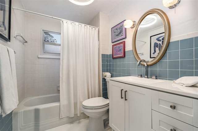 full bathroom with vanity, toilet, tile walls, and shower / bath combo