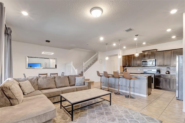 living room with a textured ceiling and light tile patterned floors