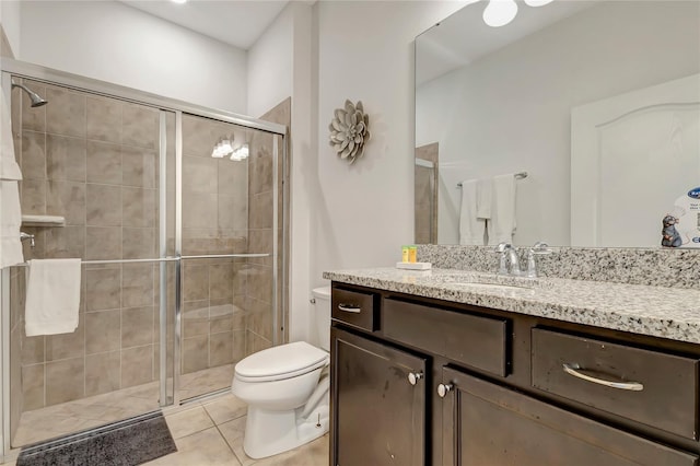 bathroom featuring tile patterned floors, vanity, toilet, and a shower with shower door