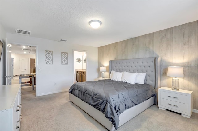 carpeted bedroom with connected bathroom and wood walls