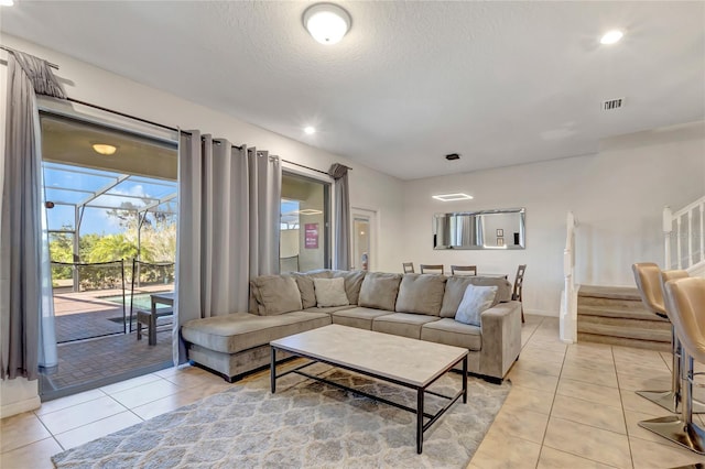 living room with a textured ceiling and light tile patterned floors