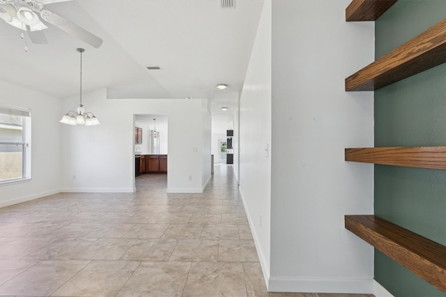 hallway with lofted ceiling and a chandelier