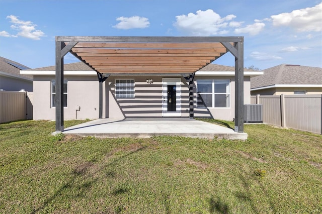 back of property with a yard, a pergola, and a patio