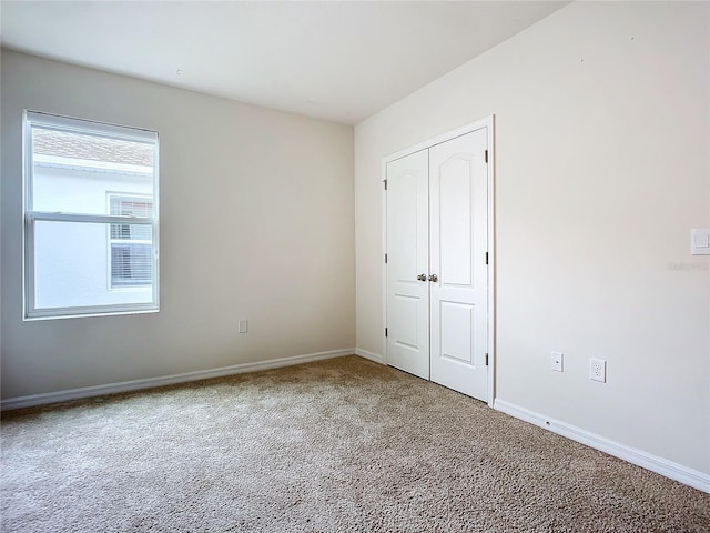 unfurnished bedroom featuring carpet flooring and a closet