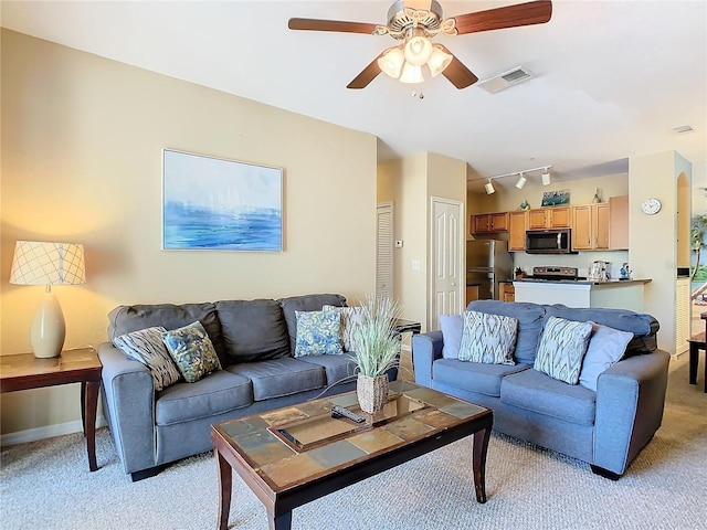 carpeted living room with rail lighting and ceiling fan