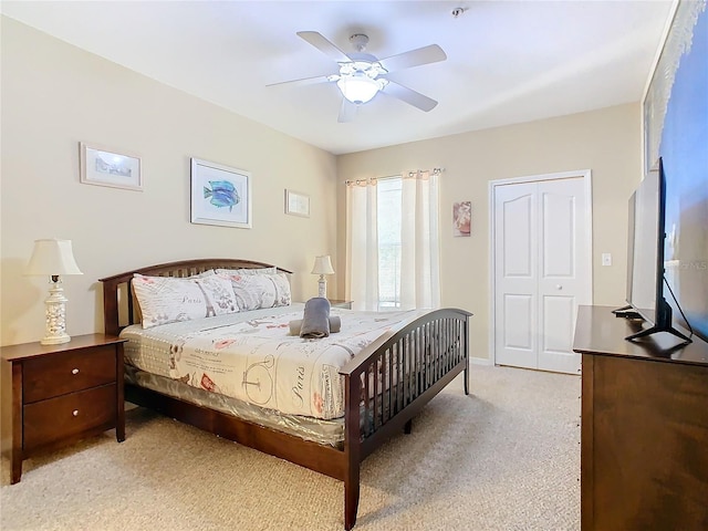 carpeted bedroom featuring ceiling fan and a closet