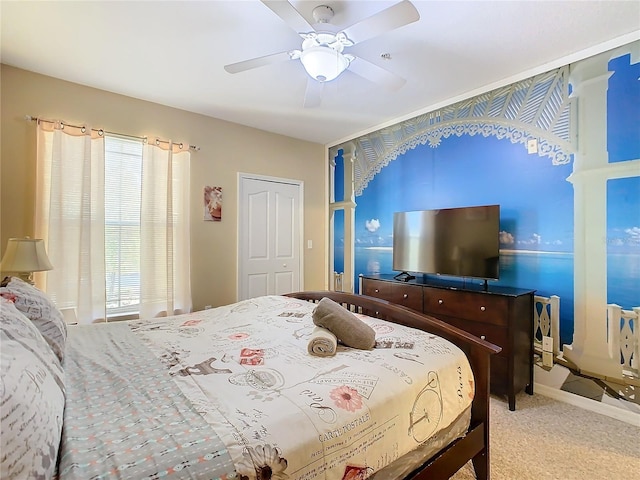 bedroom featuring light colored carpet, a closet, and ceiling fan