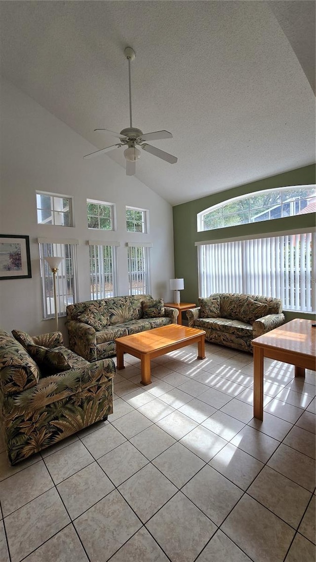 tiled living room featuring high vaulted ceiling, a healthy amount of sunlight, a textured ceiling, and ceiling fan