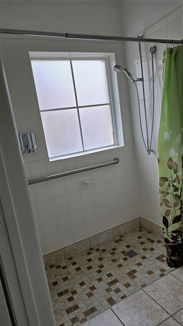 bathroom featuring walk in shower and tile patterned flooring