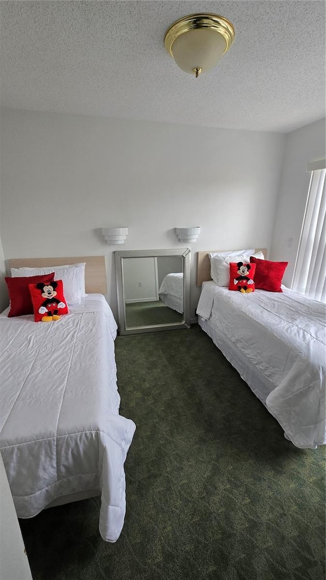 bedroom with a textured ceiling and dark colored carpet