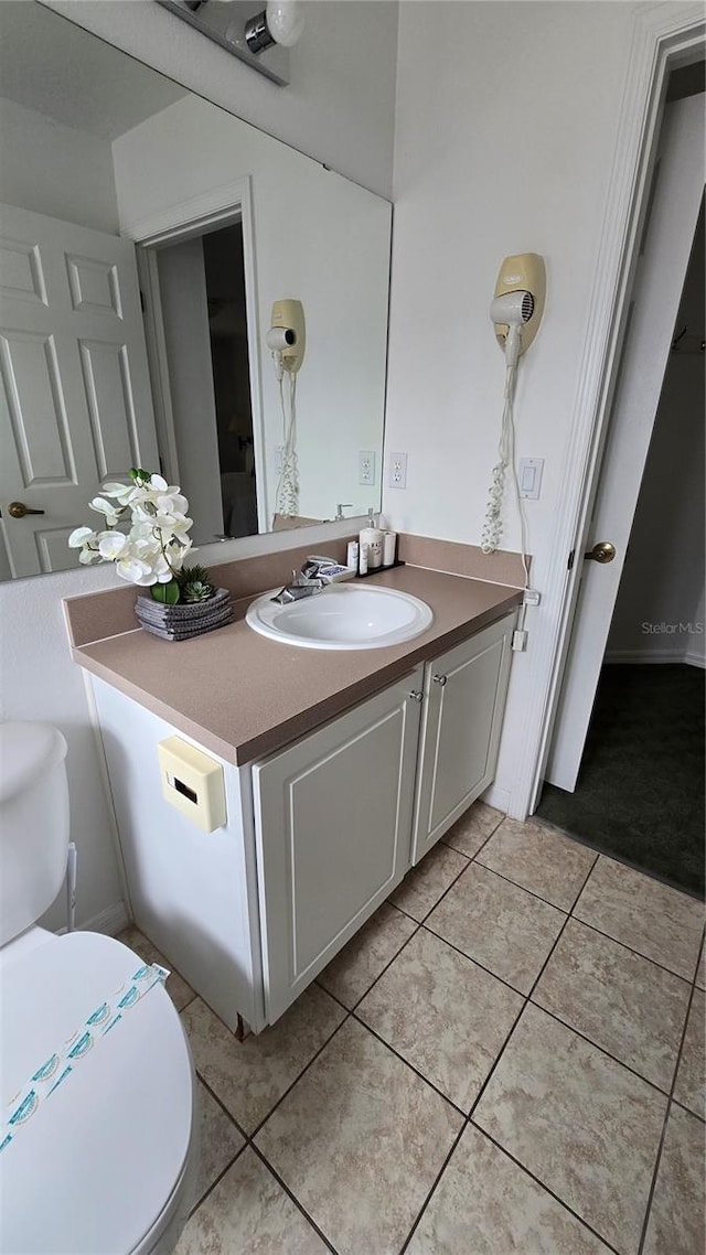 bathroom with vanity, tile patterned floors, and toilet